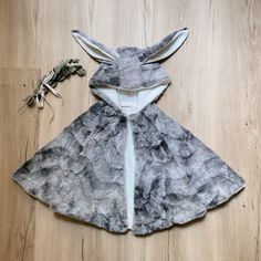 a gray and white animal costume sitting on top of a wooden floor