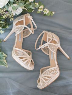 the bride's shoes and bouquet are sitting on top of her wedding dress sheet