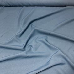 a blue sheet that is laying on top of a bed