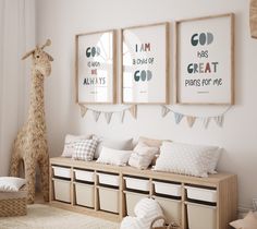 a room with some pictures hanging on the wall and stuffed giraffe in the corner