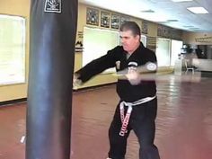 a man standing next to a punching bag