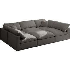 a large gray couch with pillows on the bottom and back ends, sitting in front of a white background