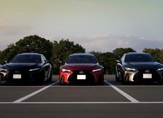 three cars parked in a parking lot next to each other with trees in the background