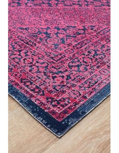 a pink and blue rug on top of a wooden floor