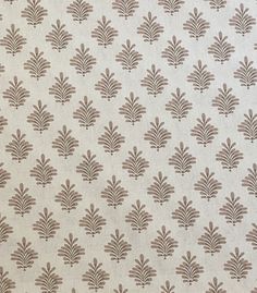 a white and brown wallpaper with small leaf designs on it's side,