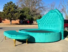 a blue bed sitting in the middle of a parking lot