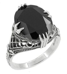 This gorgeous Art Deco sterling silver black onyx filigree ring showcases a securely claw prong set faceted shimmering natural black black onyx oval gemstone atop a cage of vintage filigree accented with granulation, engraving, and bows.Perfect for wear as a right hand ring, statement ring or cocktail ring, this wonderful antique style onyx ring is sure to become a treasured favorite for anyone who loves to wear black, or who simply enjoys bold rings that attract attention! Gothic Filigree, Dark Deco, Art Deco Filigree, Antique Jewellery Online, Right Hand Ring, Claw Ring, Bold Rings, Claw Prong, Right Hand Rings