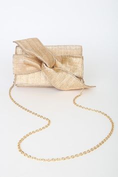 Lulus Exclusive! Add a final touch to your perfect vacation with the Lulus Perfect Retreat Bronze Woven Bow Clutch! This chic clutch is composed of textured, metallic fabric that shapes a sturdy design and a fold-over top with an oversized bow accent. A hidden magnetic closure opens to a lined interior with three separate compartments and a single zippered sidewall pocket. Attachable gold chain strap and gold hardware. Lined. Clutch Measures 8. 75" Wide, 5. 5" Tall, And 1" Deep. Detachable 48" G Gold Evening Bag For Formal Summer Events, Gold Clutch For Formal Summer Events, Gold Clutch For Summer Events, Chic Gold Evening Bag For Summer, Summer Event Gold Clutch, Gold Summer Clutch Evening Bag, Gold Evening Bag For Summer Events, Gold Summer Evening Bag For Party, Gold Summer Party Evening Bag