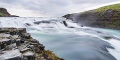 the water is rushing down the side of the waterfall