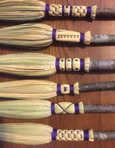 four different types of brooms are lined up on a table with purple trimming