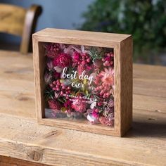 a wooden box with flowers in it sitting on a table