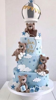 a three tiered cake with teddy bears on it