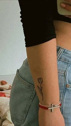 a woman with a flower tattoo on her left arm and the back of her waist