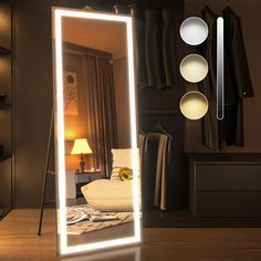 a large mirror sitting on top of a wooden floor next to a lamp and chair