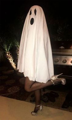 a woman dressed in a ghost costume posing for the camera with her legs crossed and shoes on