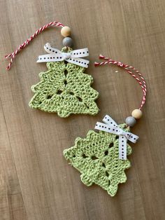 two green crocheted ornaments on a wooden table