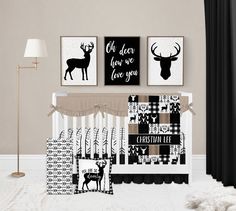 a baby crib with black and white prints on the wall next to two deer posters