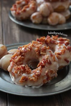 two donuts covered in bacon sitting on top of a plate next to each other