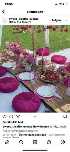 the table is set up with pink and white plates, napkins, candles and flowers