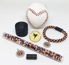 a baseball bat, bracelets, and ball on a white table with other items