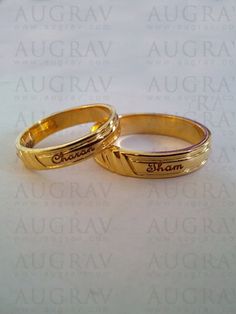 two gold wedding rings sitting on top of a white surface with words written in the middle