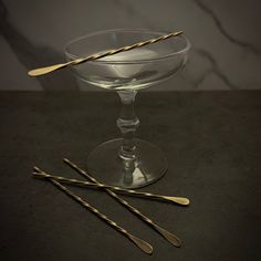 three gold colored spoons in a glass bowl