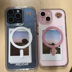 two cell phones sitting next to each other on top of a wooden table and one has a magnifying glass in it