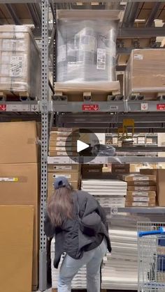 a woman is moving boxes in a warehouse