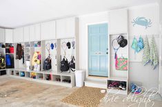 a room filled with lots of white cupboards and bags on top of it's shelves