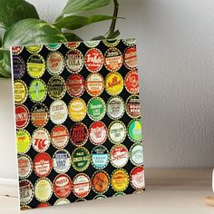 an assortment of beer bottle caps on a black background art board print