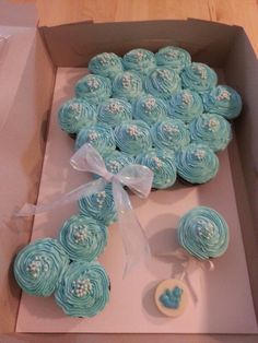 a box filled with blue cupcakes on top of a table