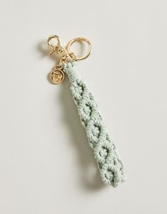 a crocheted keychain with a gold charm hanging from it's end