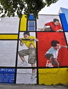 a large mural painted on the side of a building with children playing and skateboarding