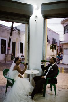 a bride and groom sitting at a table in the middle of an open air courtyard