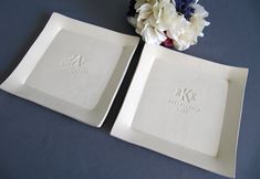 two white square plates with initials on them