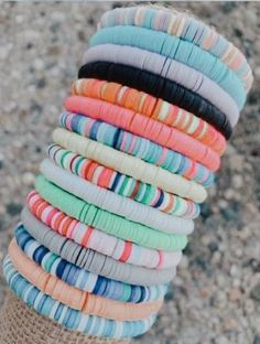 a person is holding up a stack of bracelets