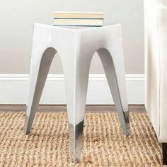 a white stool sitting on top of a rug