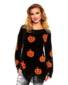 a woman wearing a black sweater with pumpkins on it