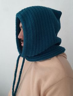 a woman wearing a knitted hood with braids