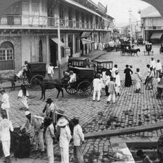 an old black and white photo of people on the street in front of some buildings