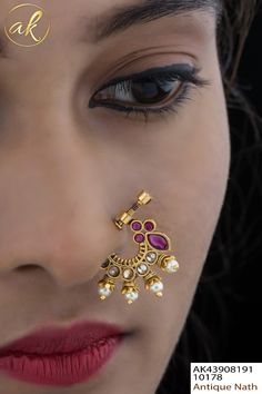 a close up of a woman's face with jewelry on her nose