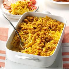 a casserole dish with meat and cheese in it on a white tablecloth