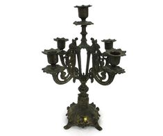 an ornate bronze candelabra with candles on it's sides, possibly from the 19th century