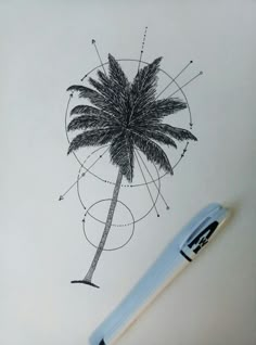 a drawing of a palm tree on paper with a pen next to it and an object in the background