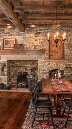 a rustic dining room with stone fireplace and wood table set for four, surrounded by antique rugs