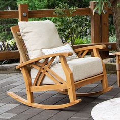 a wooden rocking chair sitting on top of a brick patio