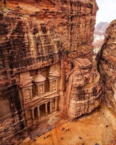 an aerial view of the ancient city carved into the side of a cliff in jordan