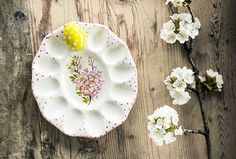 a white plate with flowers on it next to a yellow and white flowered object