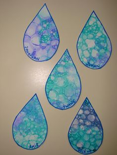 four pieces of paper that have been made to look like raindrops with blue and green paint on them