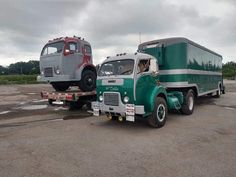 two trucks parked next to each other in a parking lot with cloudy skies behind them